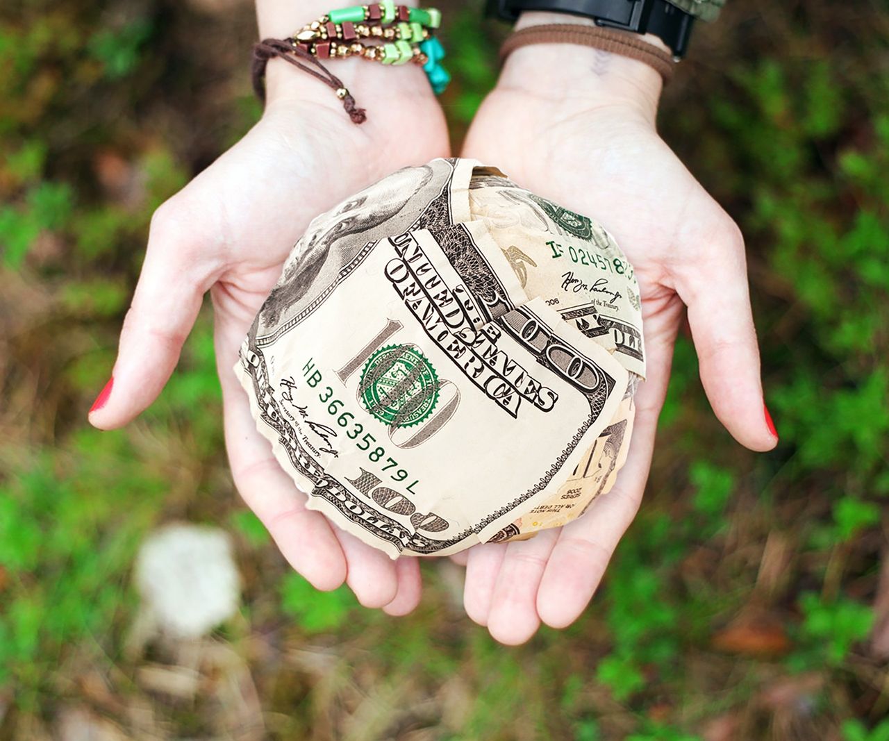 cta-image Hands holding crumpled money outdoors, symbolizing charity and financial support.